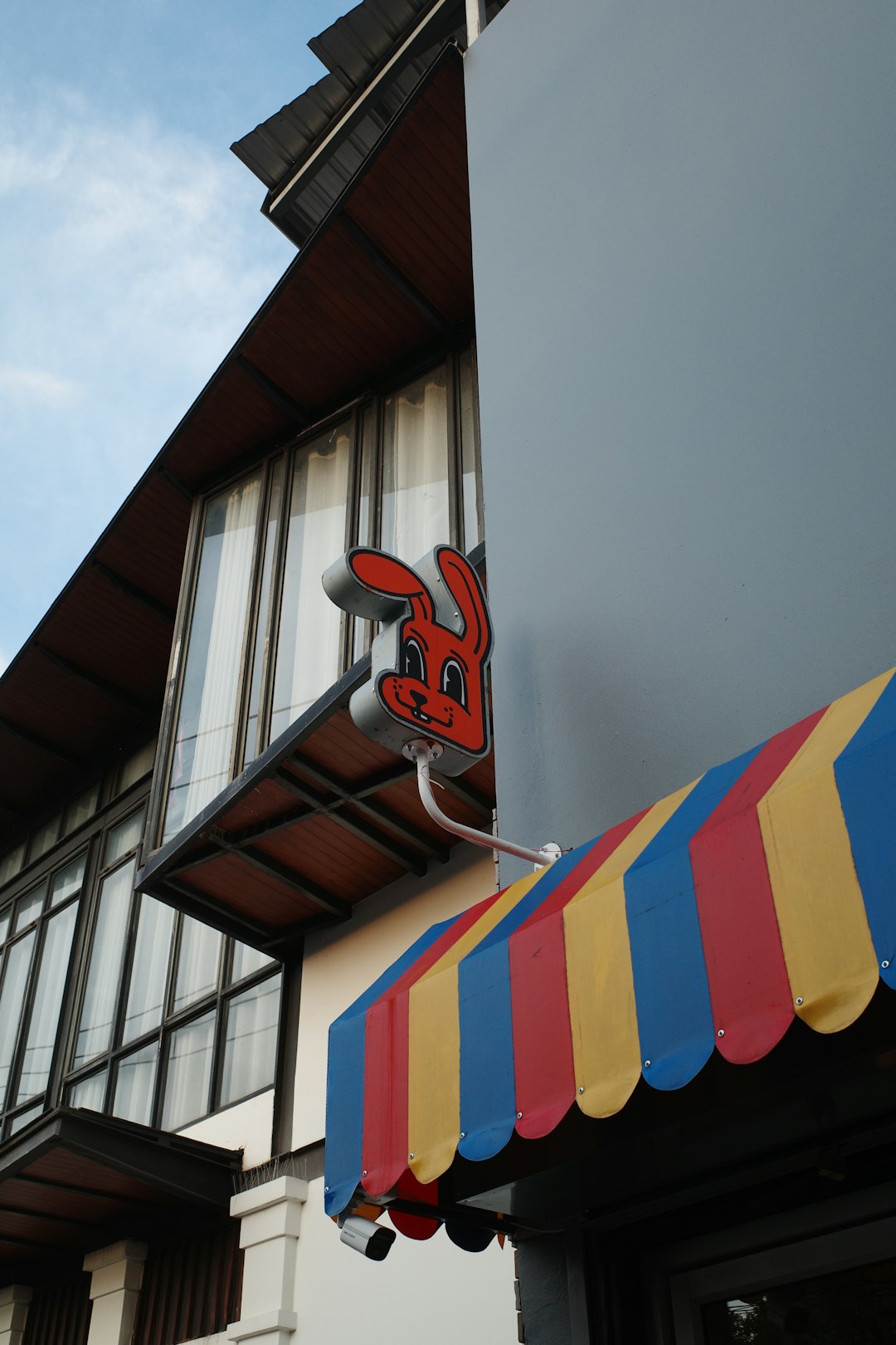 A building with a bunny sign and striped awning